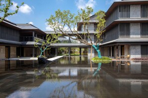 A modern building with a reflective water feature in the courtyard. - Holiday Inn Deqing Xinshi Ancient Town (Huzhou)