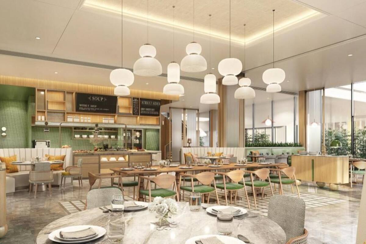 Un restaurante moderno con barra central, mesas de comedor e iluminación colgante.