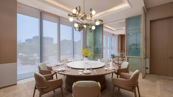 A modern dining room with a round table, six chairs, and a chandelier.
