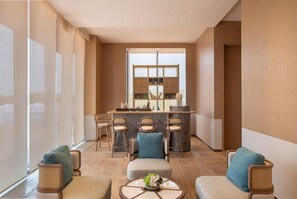 A modern hotel lobby with a bar area, seating with cushions, and a large window providing natural light. - Holiday Inn Deqing Xinshi Ancient Town (Huzhou)
