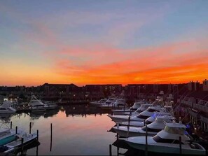 Uma marina com barcos atracados no cais durante o pôr do sol.