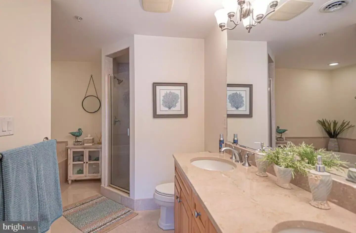 A modern bathroom with a shower, toilet, and vanity with a sink and mirror.