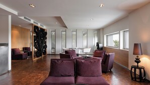 A modern interior with a purple sofa set, a round table, and a TV. - Valbusenda Hotel Bodega and Spa (Toro)