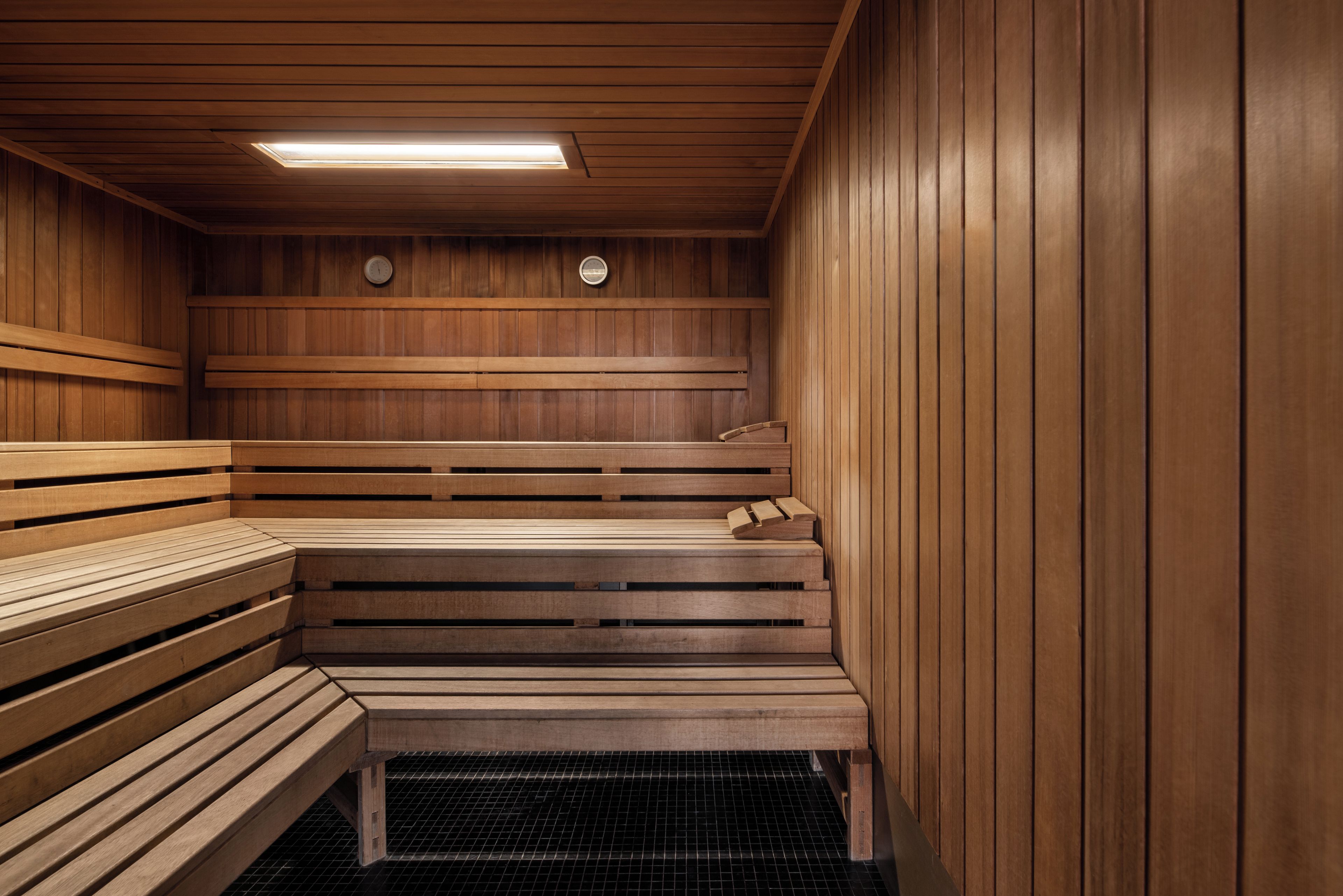 Una sauna con bancos de madera y suelo de baldosas.