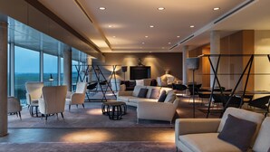 A modern interior with a large seating area, a dining table, and a view through large windows. - Valbusenda Hotel Bodega and Spa (Toro)