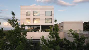 Un edificio moderno de dos pisos con ventanas grandes y techo plano.