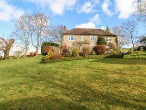 A two-story house with a well-maintained lawn and mature trees. - The Old Croft (Buxton)
