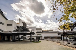 A courtyard with modern buildings, a traditional pavilion, and a clear sky. - Yingzhouyuan Hotel (Huili)