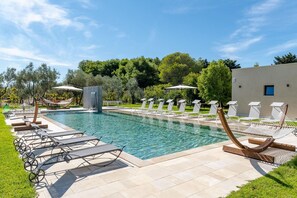 Relax by the pool surrounded by lush greenery and a soothing waterfall.