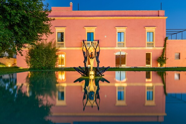 Stately building with a central entrance and reflective pool, showcasing a blend of classic and modern design elements.