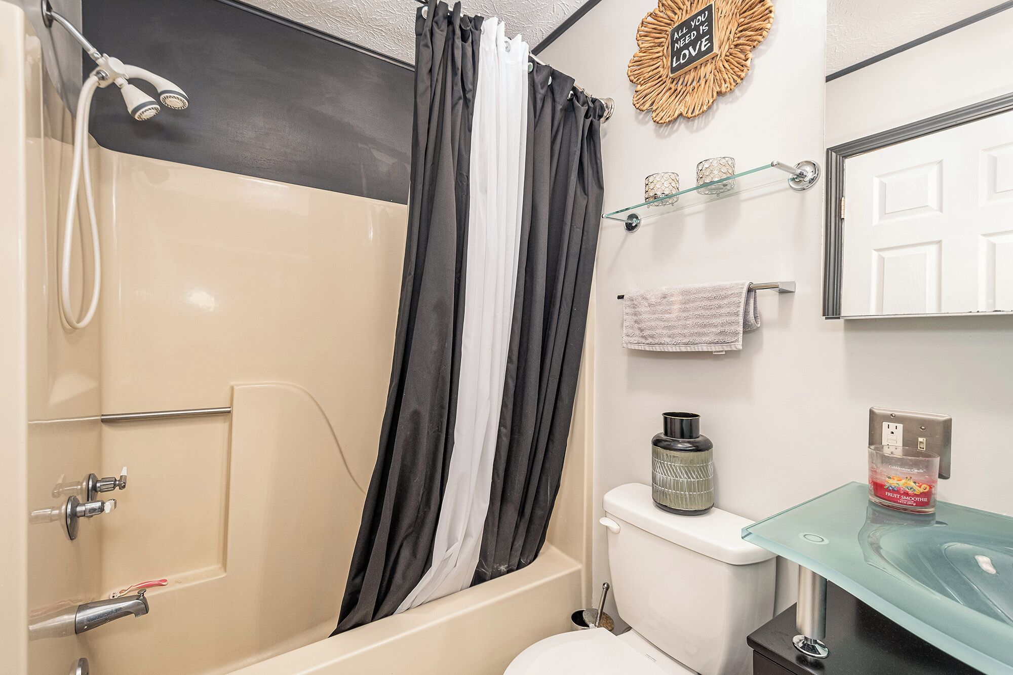 A bathroom with a shower, toilet, and sink.
