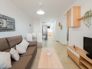 Ein modernes Wohnzimmer mit einem braunen Sofa, einem Couchtisch, einem Fernseher und Holzausbau.