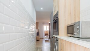 A modern kitchen with white subway tiles, stainless steel appliances, and wooden cabinetry. - Cubo's Ideal Alhaurin Job / urban / ideal for teleworking (Alhaurín el Grande)