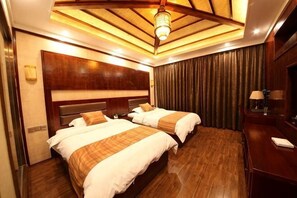 A hotel room with two beds, wooden headboards, a ceiling light fixture, a wooden floor, and a large mirror. - Dege Shandi Hotel (Dege)