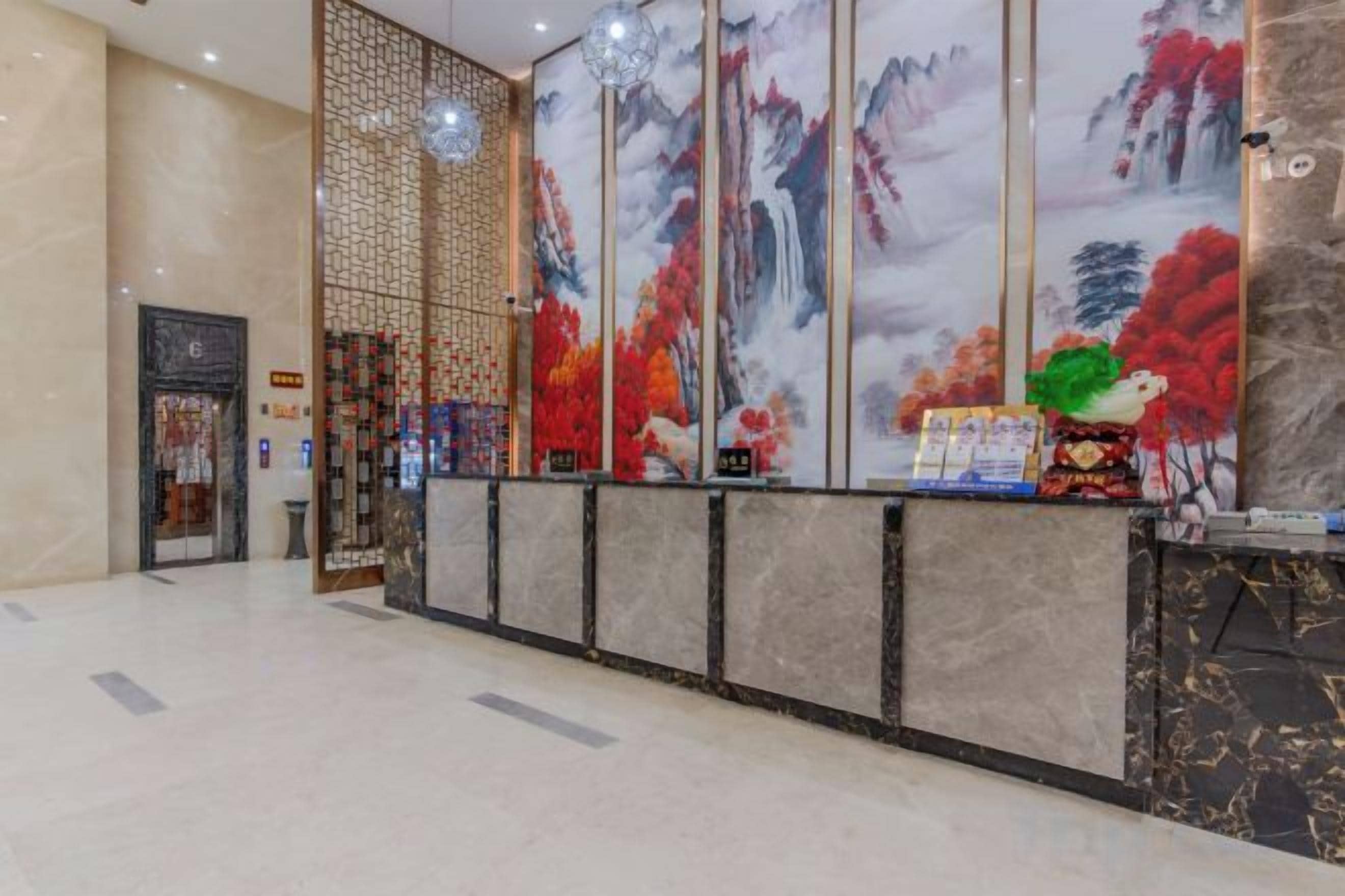 A reception area with a decorative screen, a reception desk, and a large painting.