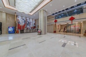 A spacious lobby with a reception desk, a digital information kiosk, and a large artwork on the wall. - Chang Jin Hotel, Luxi (Luxi)