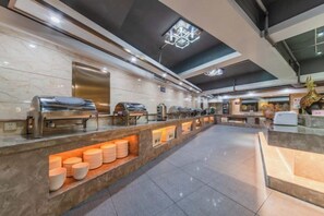 A buffet area with a marble countertop, various food stations, and a tiled floor. - Chang Jin Hotel, Luxi (Luxi)