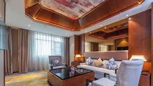 Ein Hotelzimmer mit einer Couch, einem Sessel und einem Glastisch.