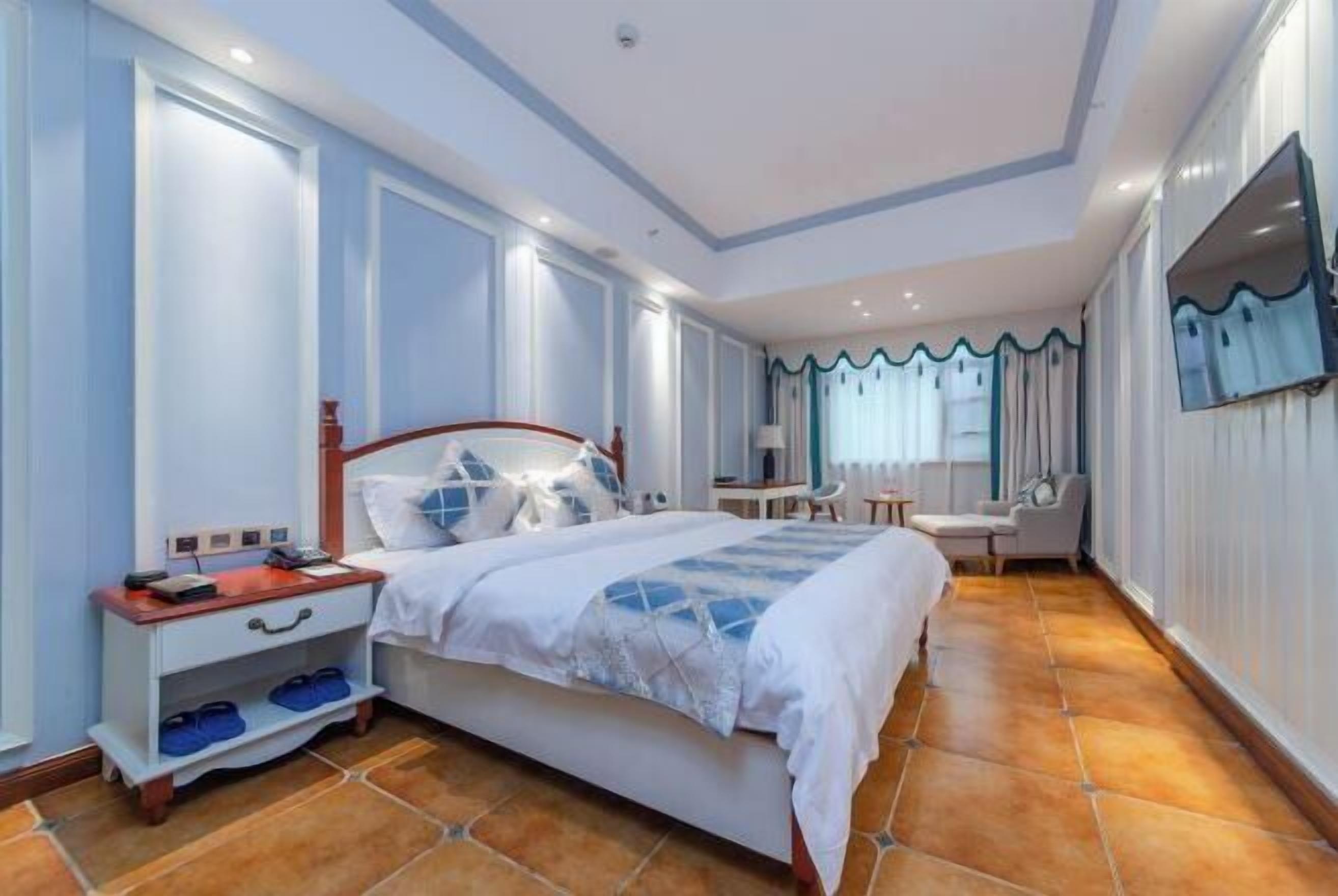 Una habitación de hotel con una cama grande, una mesita de noche y un escritorio pequeño con una silla.
