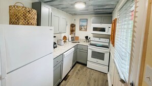 A compact kitchen with white appliances, a microwave, and a sink. - Relax in this cozy townhouse, 2block to the beach (Myrtle Beach)