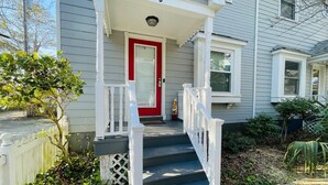 A house with a red door, white railings, and a porch. - Relax in this cozy townhouse, 2block to the beach (Myrtle Beach)