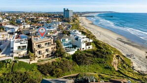 Une zone résidentielle côtière avec des maisons modernes, une plage et une jetée.
