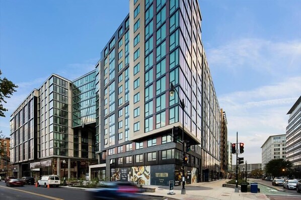 Un edificio moderno de varios pisos, con amplios ventanales y una entrada destacada con un letrero.