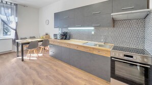 Una cuina moderna amb armaris grisos, taulell de fusta i forn integrat.