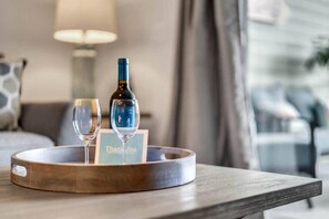 A tray with a wine bottle, a glass, and a thank you card on a wooden table in a hotel room. - Bahama Bay- Upgraded condo with patio (Davenport)