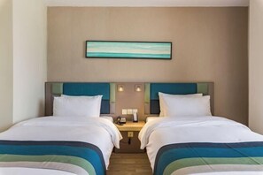 A hotel room with two beds, a nightstand, a phone, and a painting on the wall. - Homeinn Selected Hotel (Xuzhou Suning Plaza Hubu Mountain Subway Station) (Xuzhou)