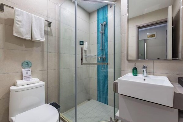 A bathroom with a glass-enclosed shower, a white sink with a mirror, and a toilet. - Homeinn Selected Hotel (Xuzhou Suning Plaza Hubu Mountain Subway Station) (Xuzhou)