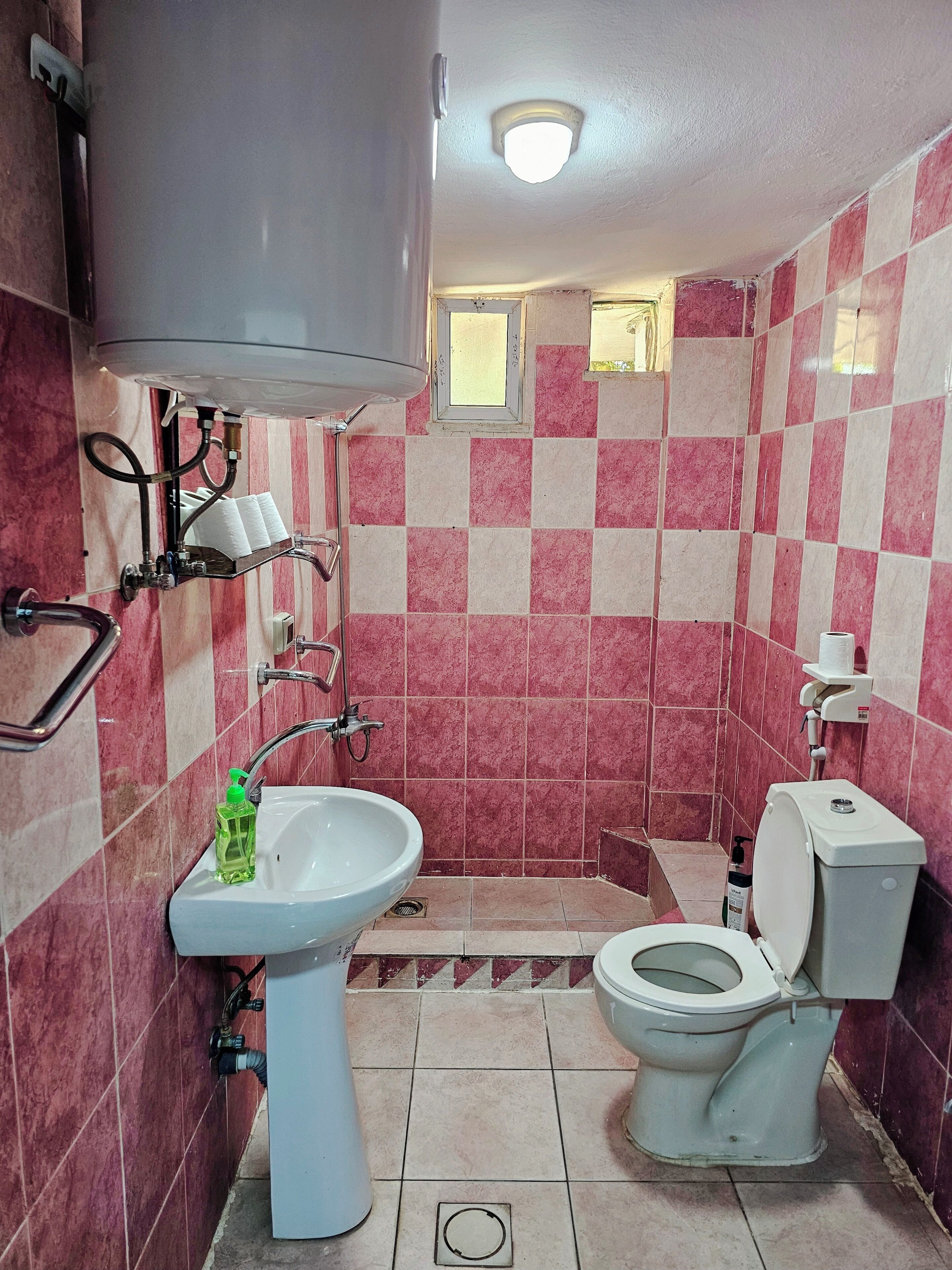 A bathroom with a sink, toilet, and shower.