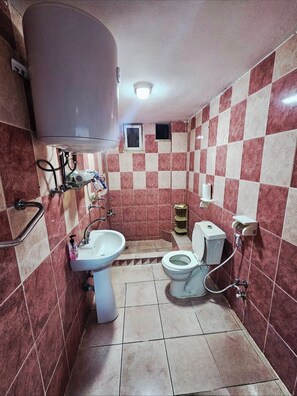 A small bathroom with a sink, toilet, and a water heater.
