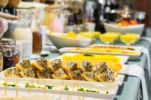 A buffet with various food items including sliced fruits and beverages. - Xima Central Tacna (Tacna)