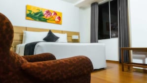 A hotel room with a bed, a painting on the wall, a chair, and a window with curtains. - Xima Central Tacna (Tacna)