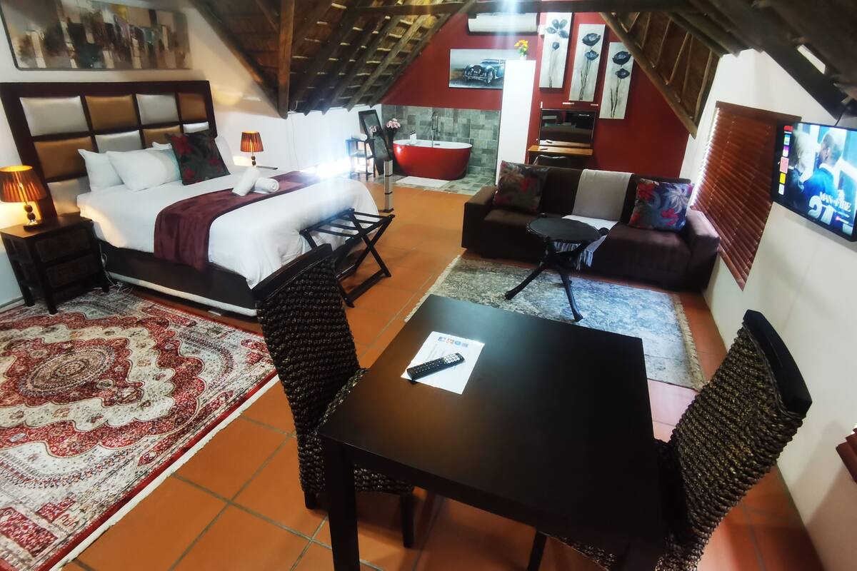 Una habitación acogedora con una cama, una mesa de comedor y un sofá.