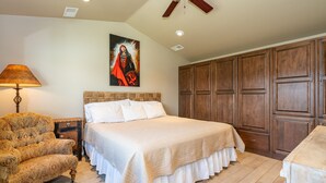 Un dormitorio con una cama grande, un armario de madera y una mesita de noche con lámpara.
