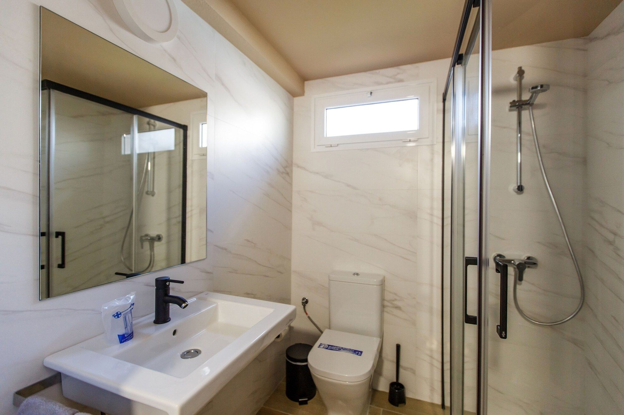 A bathroom with a sink, toilet, and glass-enclosed shower.