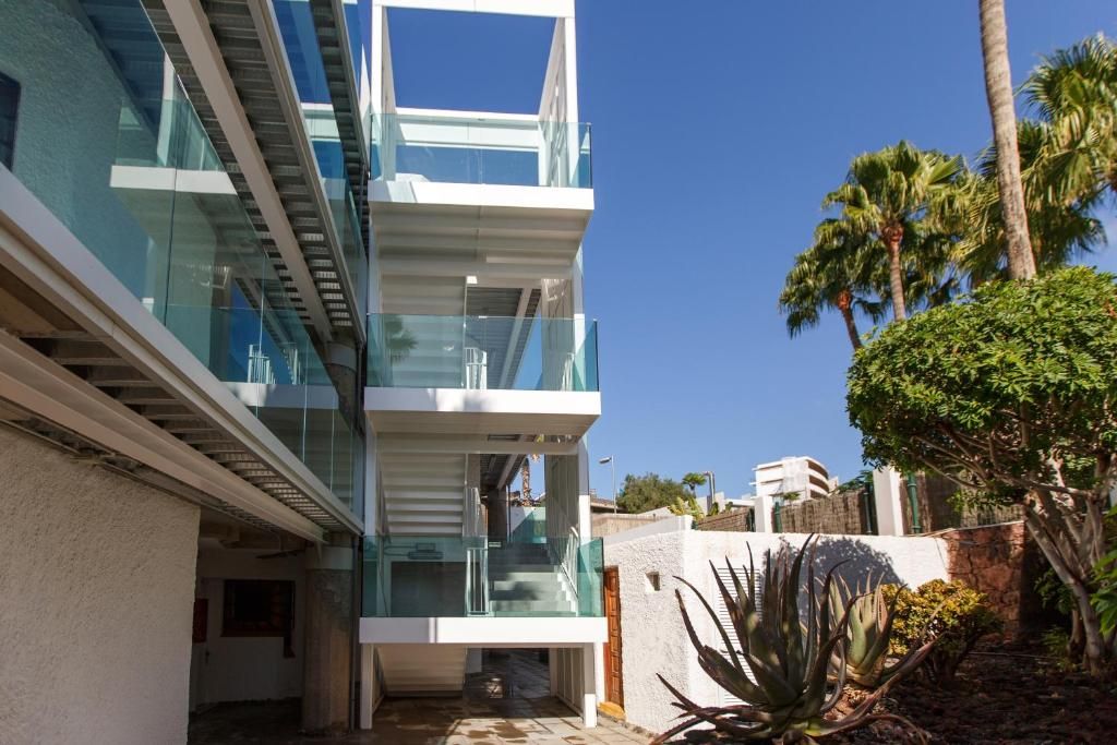 A modern multi-story building with glass balconies and a clear sky.