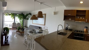 A modern kitchen with a granite countertop, stainless steel appliances, and wooden cabinets. - Cartagena Frente a la Playa 27A (Cartagena)