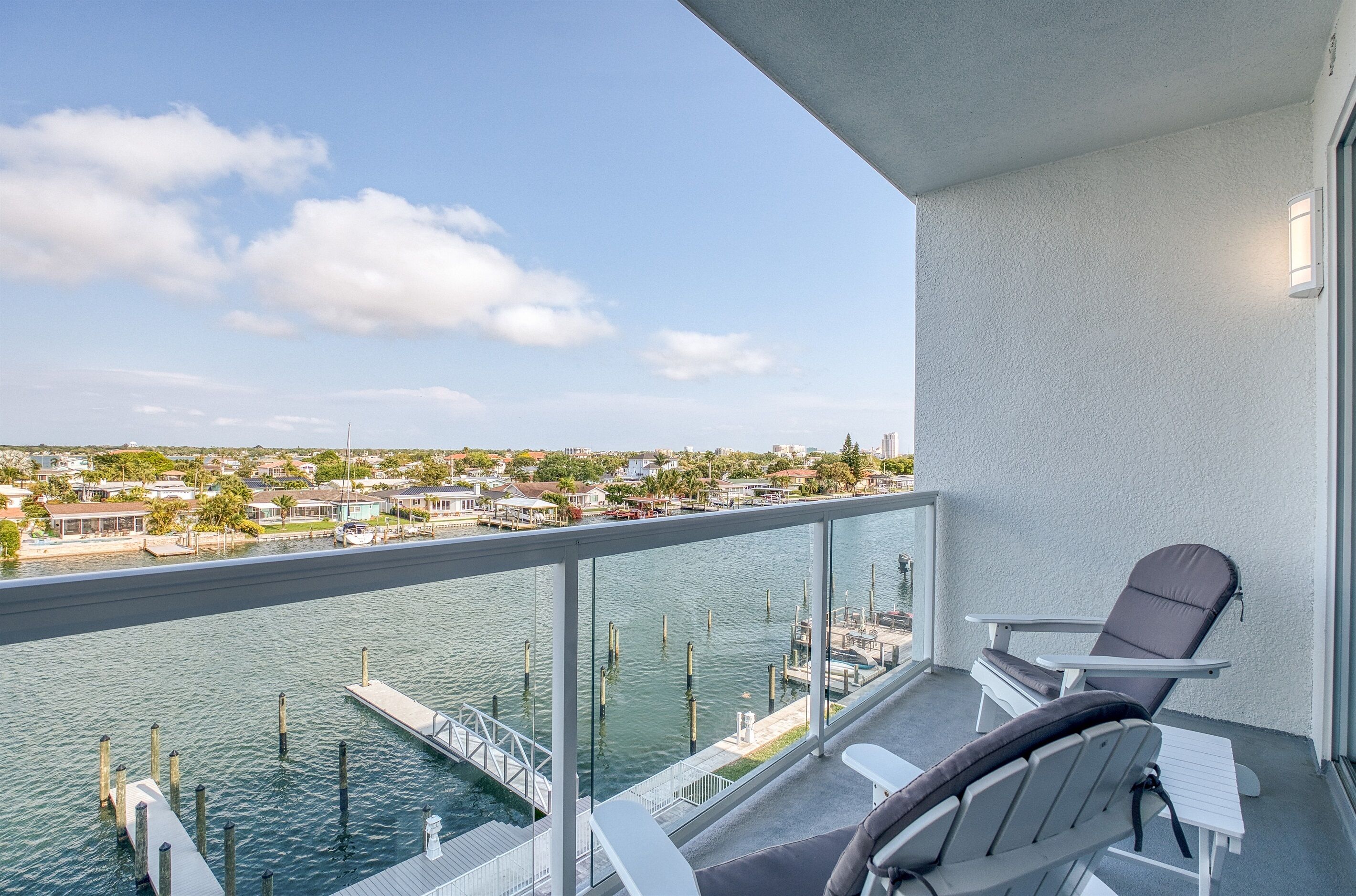 A balcony with a view of a marina and cityscape.