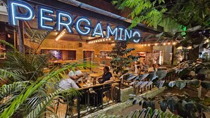 Un restaurante llamado "PERGAMINO" con mesas en el interior y una zona de bar visible.