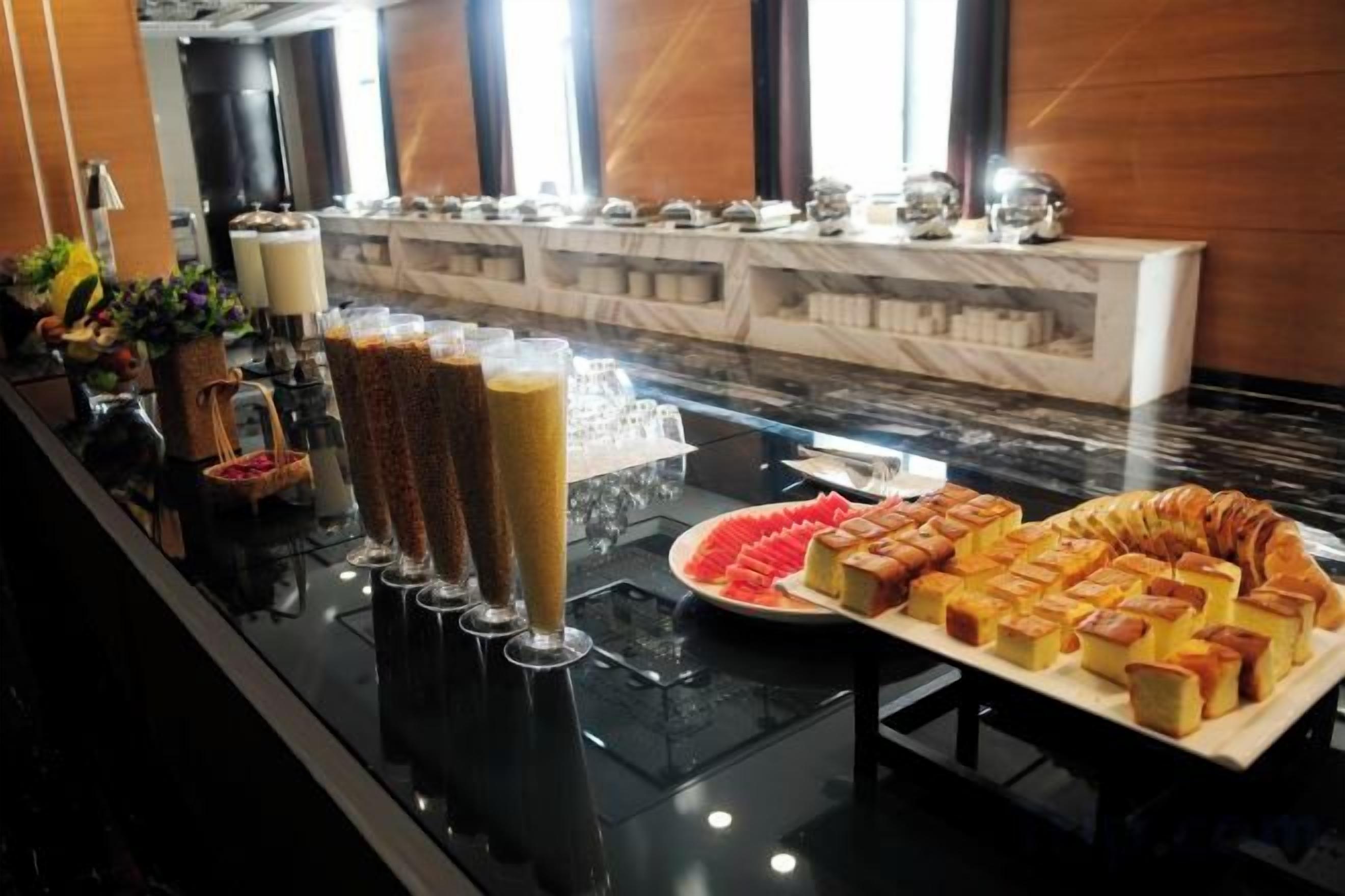 A buffet with various food items and beverages.