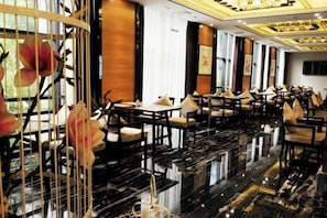 A spacious hotel lobby with a polished black marble floor, numerous tables and chairs, and large windows allowing natural light. - Baodeli Hotel (Pan'an)