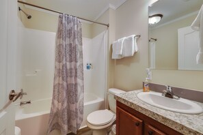 A bathroom with a bathtub, toilet, and sink. - Family Home in Rapid City ~ 4 Mi to Torch Lake! (Rapid City)