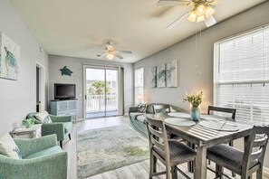 Relax in a spacious living area with a flat-screen TV, comfortable seating, and a dining table for four.
