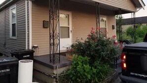 A house with a porch, a garage, and a driveway. - Lovely Midtown Home Close To ALL Downtown Action (New Orleans)