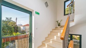 Una escalera con barandillas de madera y vistas a un jardín.