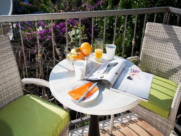 Enjoy a serene outdoor setting with a charming table for two, complete with a fruit basket and refreshing drinks.