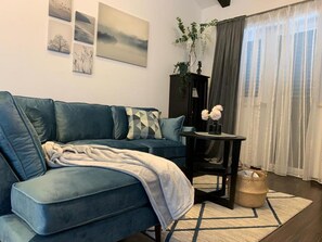 Relax in this stylish living room with a sofa, side table, and vase of flowers.